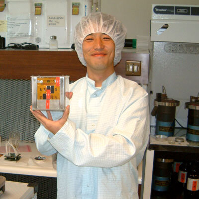 A student holds one of the smaller CubeSats