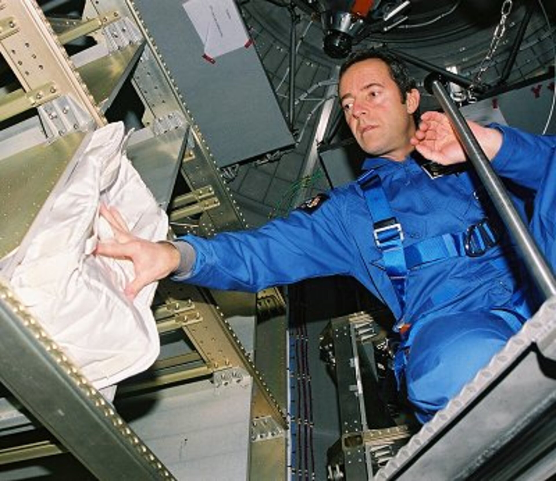 The operator and cargo bags are lowered through the opened docking system hatch