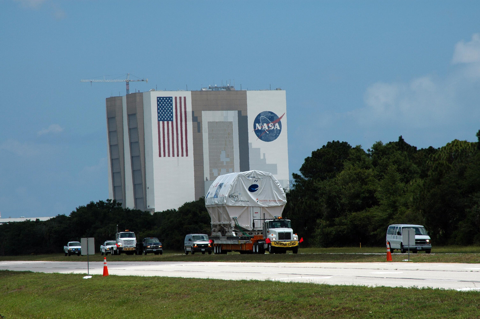 The Columbus laboratory, is moved under escort past the Vehicle Assembly Building at NASA's Kennedy Space Center