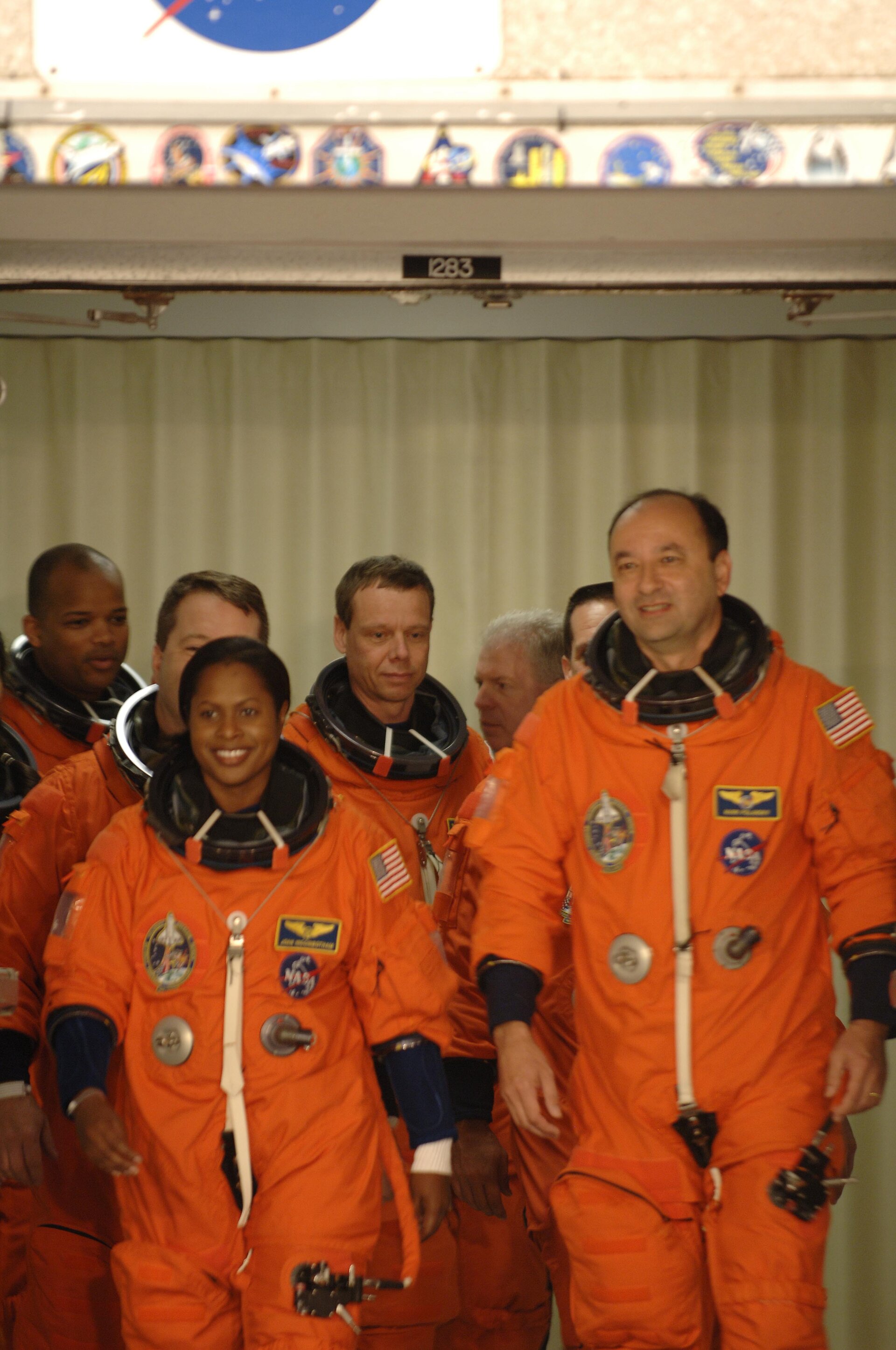 STS-116 Shuttle crew, wearing their orange Advanced Crew Escape Suits (ACES), walkout for the practice countdown at KSC