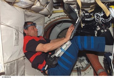Fuglesang uses a computer on the Shuttle's middeck