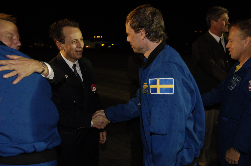 Strax efter landningen hälsar Michel Tognini, chef för det europeiska astronautcentret, Christer Fuglesang välkommen tillbaka