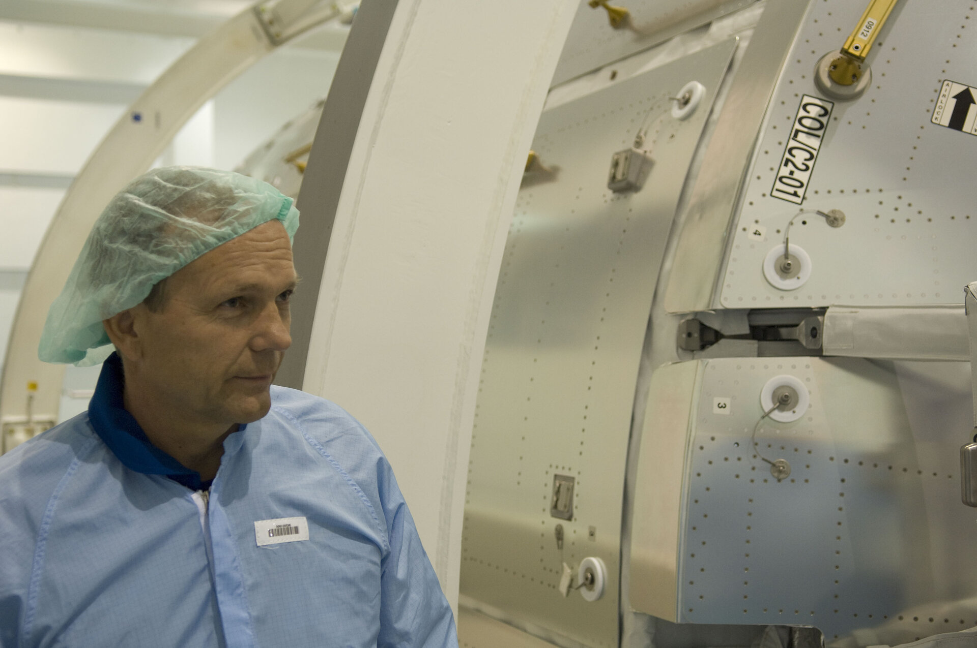 ESA astronaut Hans Schlegel inspects the European Columbus laboratory at NASA's Space Station Processing Facility