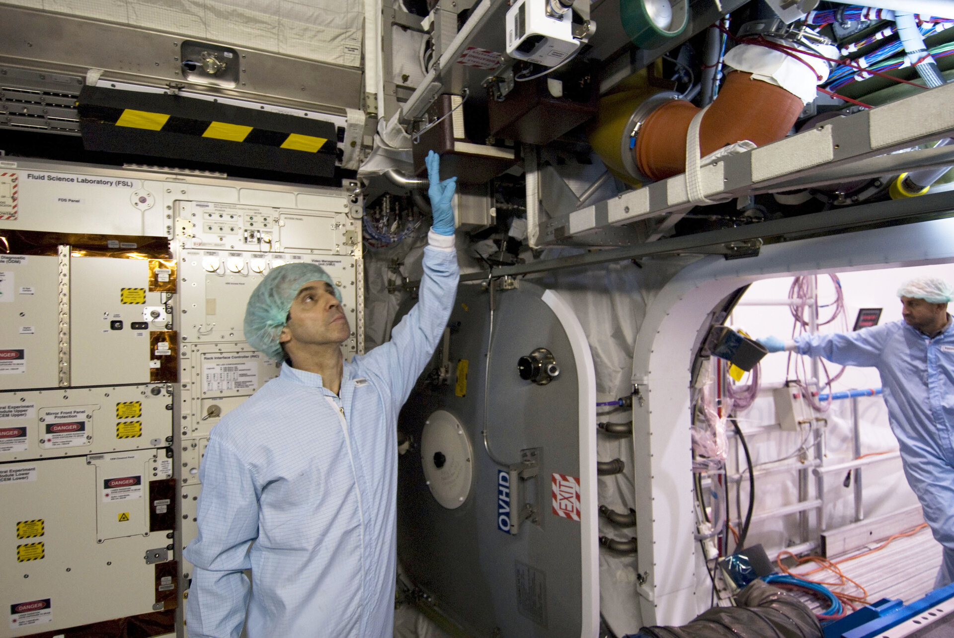 ESA astronaut Leopold Eyharts inspects the interior of the European Columbus laboratory
