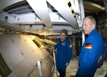 ESA astronauts Leopold Eyharts and Hans Schlegel during an inspection of Space Shuttle Atlantis