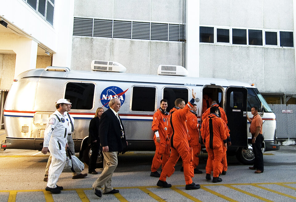 The STS-120 crew boards a bus that will transport them to the launch pad