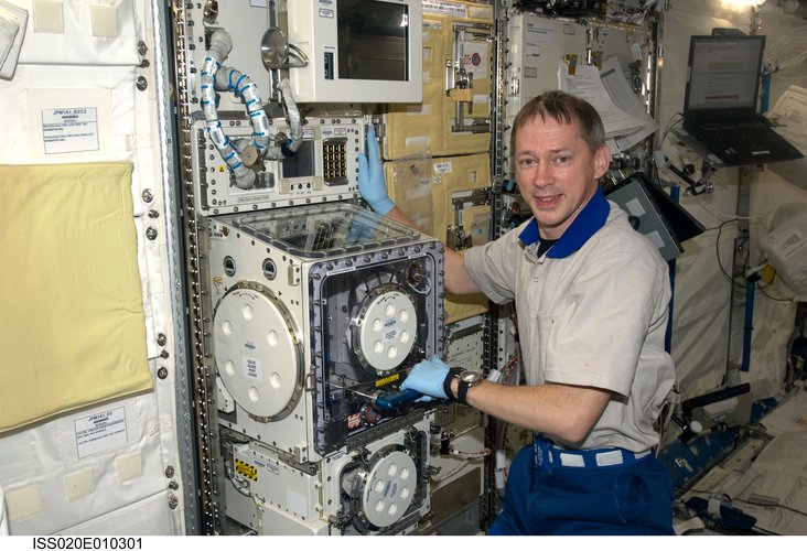 Frank De Winne works on a facility in the Kibo laboratory