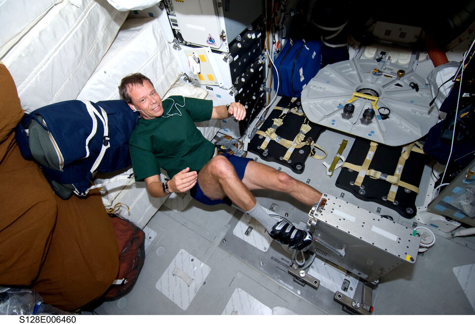 Christer Fuglesang exercises on a bicycle ergometer on Shuttle middeck