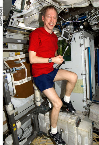 Frank De Winne exercises on the cycle ergometer in the Destiny laboratory