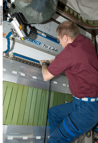 Frank De Winne works on installation of the COLBERT treadmill