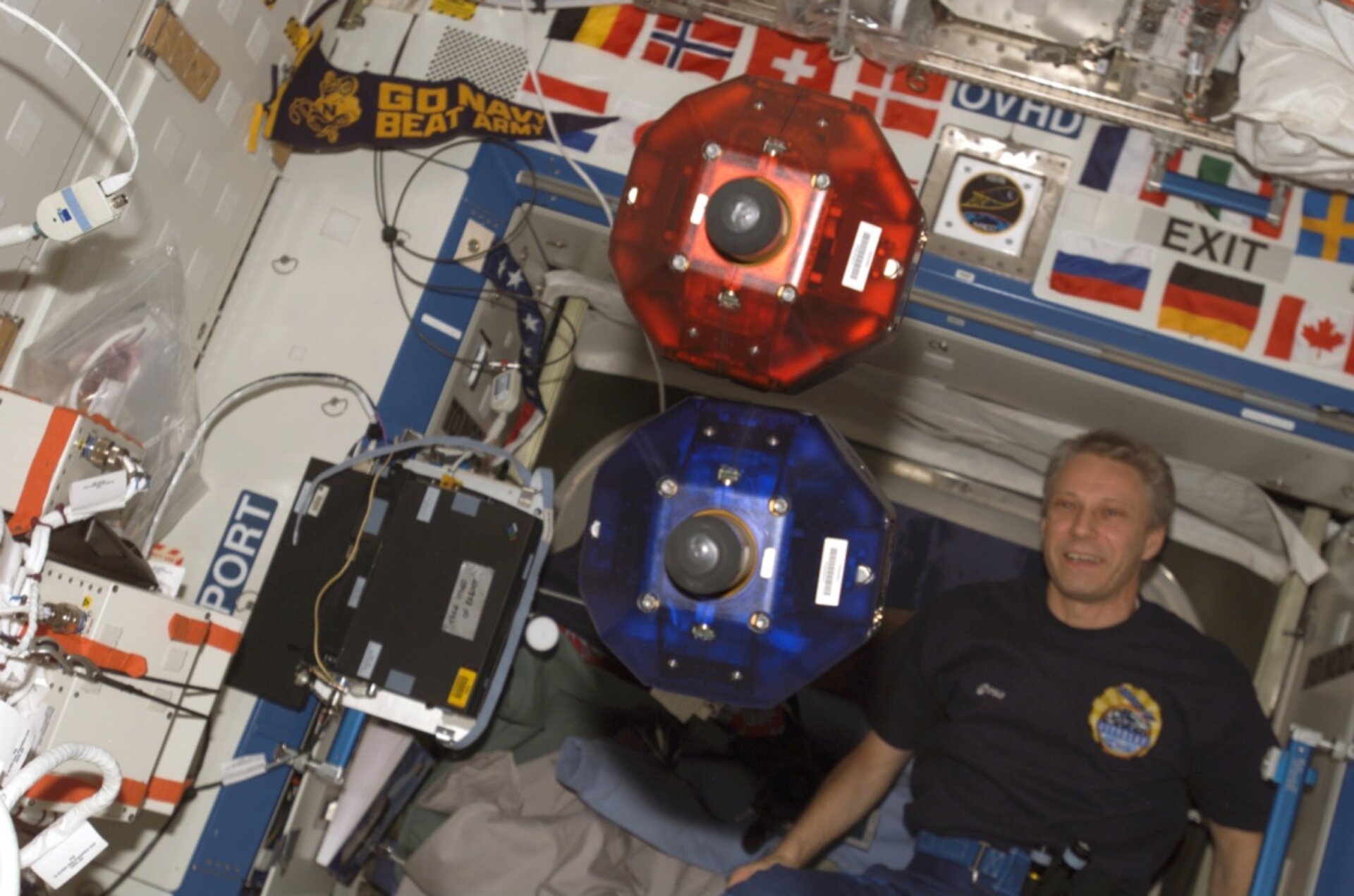 SPHERES schweben im Labormodul Destiny, fotografiert von einem Besatzungsmitglied der Expedition 14. Im Hintergrund ist Flugingenieur Thomas Reiter zu sehen.
