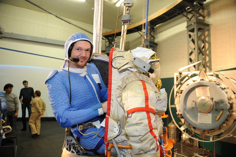 Alexander climbing into his spacesuit