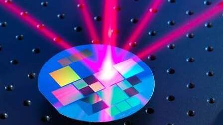 Laser beam shone on reflective wafer grating to trap atoms