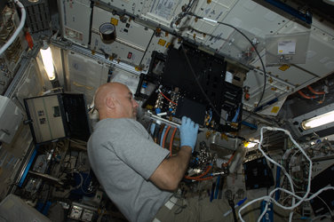 ESA astronaut Luca Parmitano installing experiment hardware on Space Station