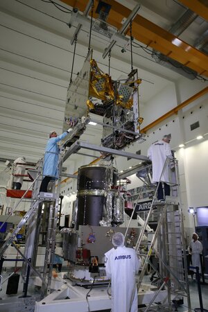 The communications module of Quantum is slowly lowered onto the service module