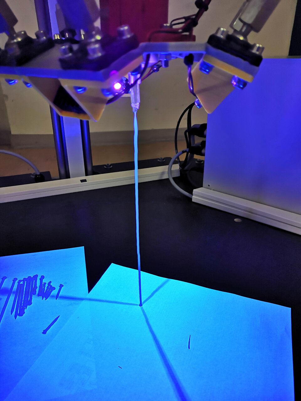 The resin being cured by UV. This, in combination with the low-g environment, allows manufacturing without the shape limitations that exist on Earth