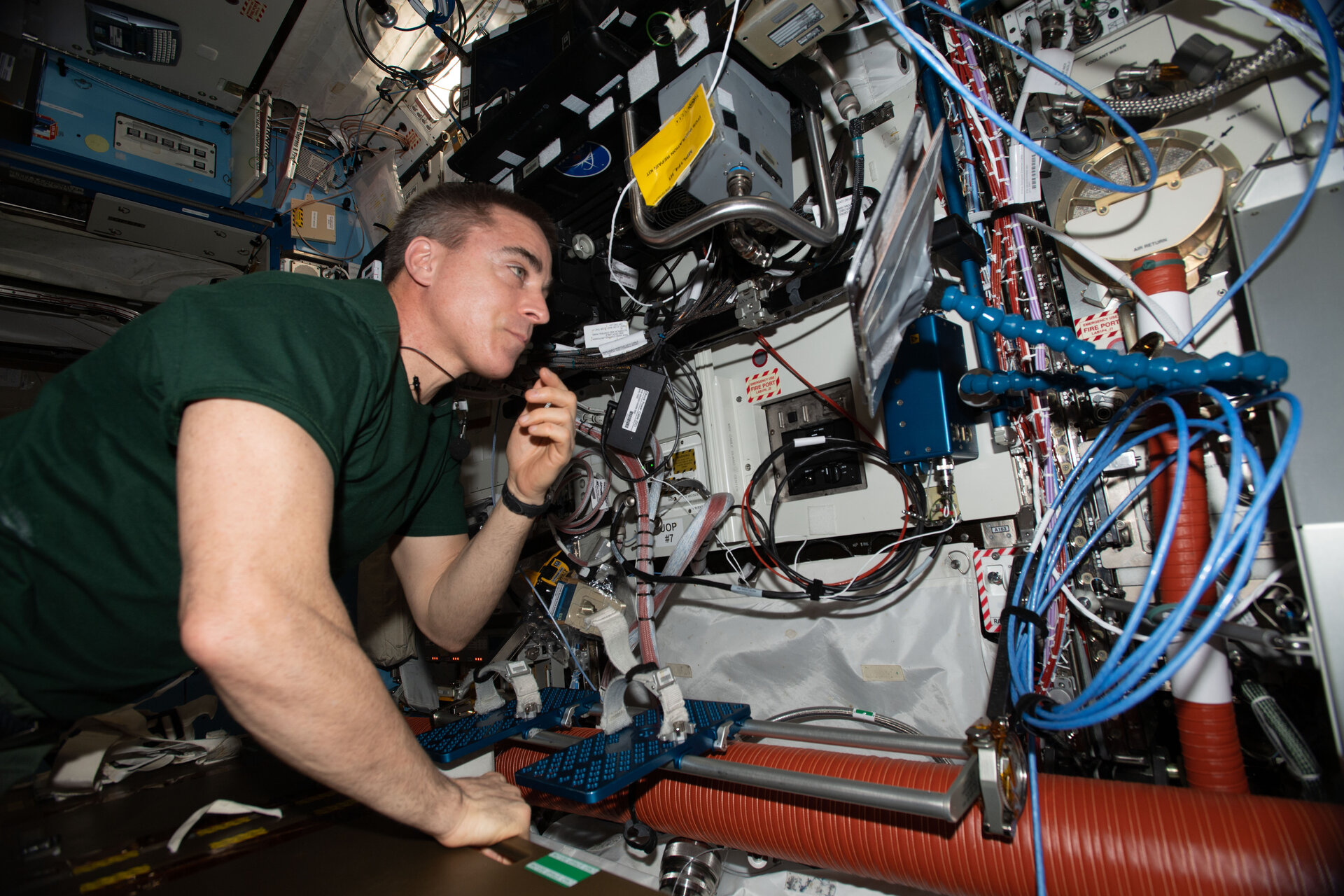 NASA astronaut and Expedition 63 Commander Chris Cassidy swaps a hard disk drive during computer maintenance on the robotics work station which controls and commands the Canadarm2 robotic arm.