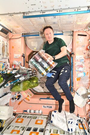 ESA astronaut Matthias Maurer holds a package of space food from Saarland on the International Space Station