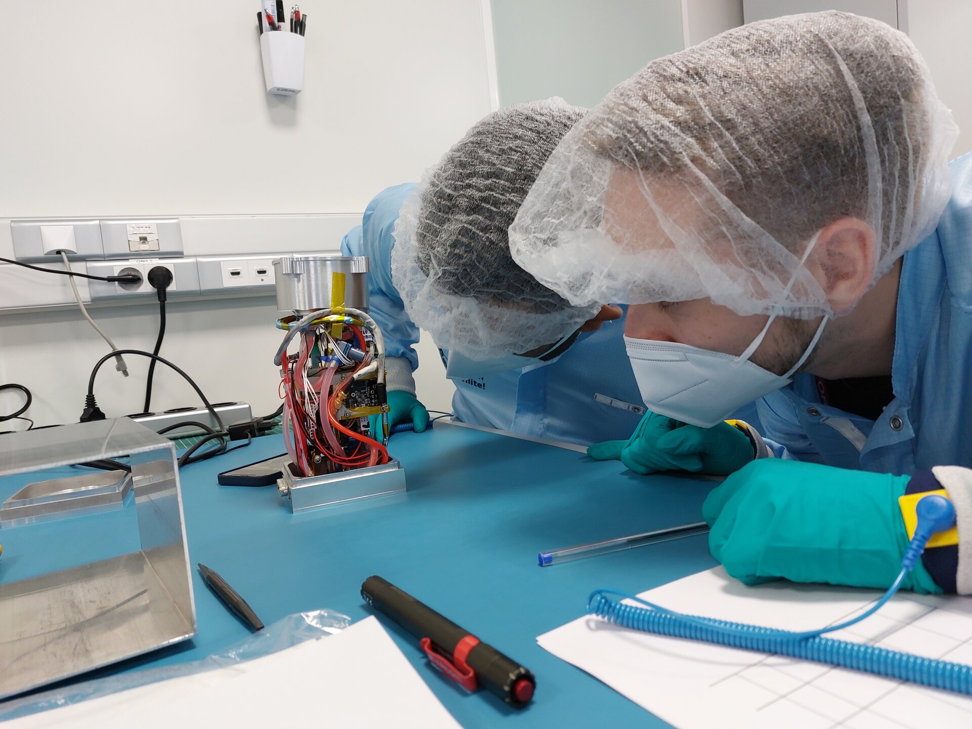 Students inspect the hardware which pumps blood like fluid through silicone arteries