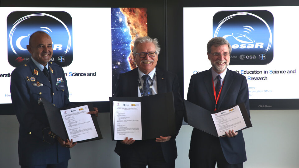 El Director de Ciencia de la ESA, el Consejero Delegado de ISDEFE y el Director General de INTA posan con el convenio CESAR de colaboración en materia de Educación