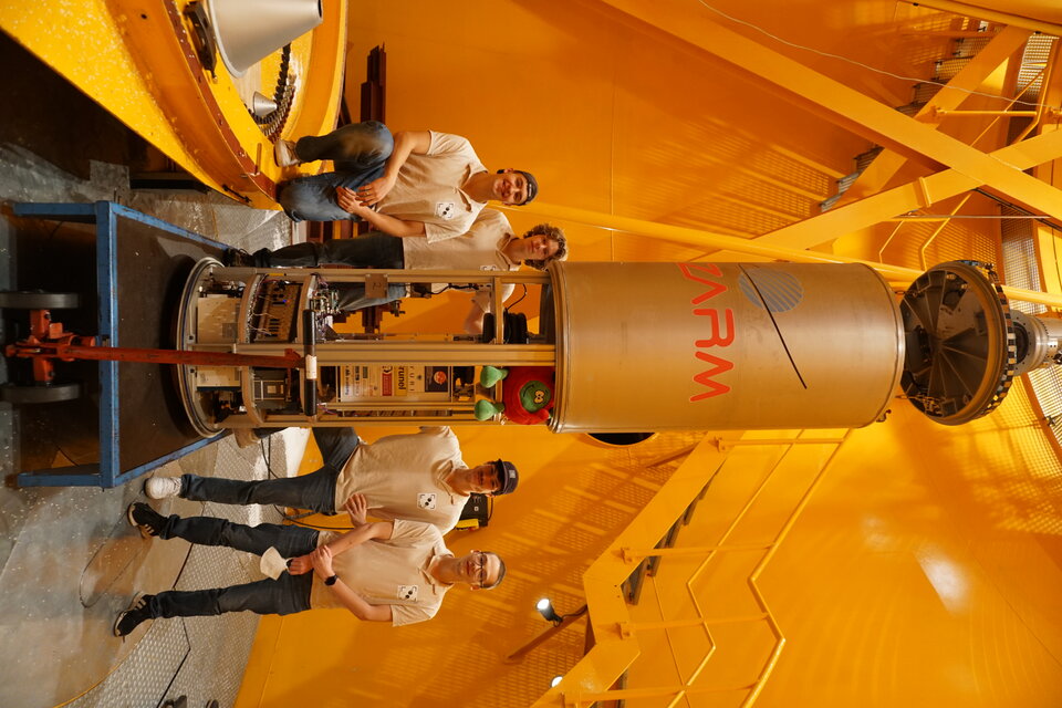 Students pose in front of their experiment in the deceleration chamber at the base of the Tower