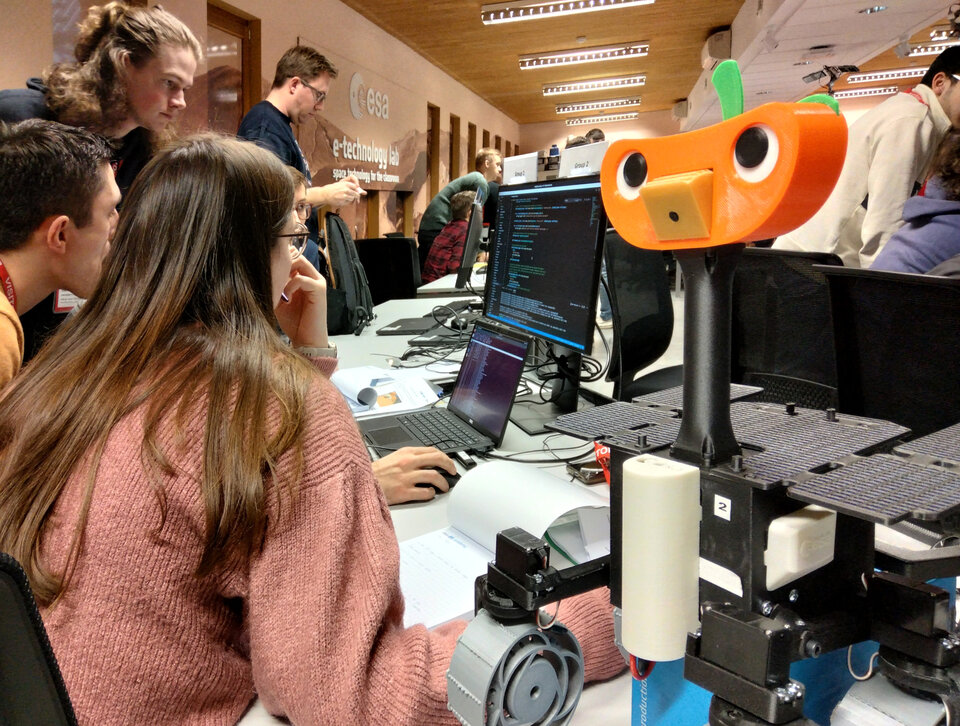 Group of students implementing code in order to move their ExoMy across a simulated Martian surface