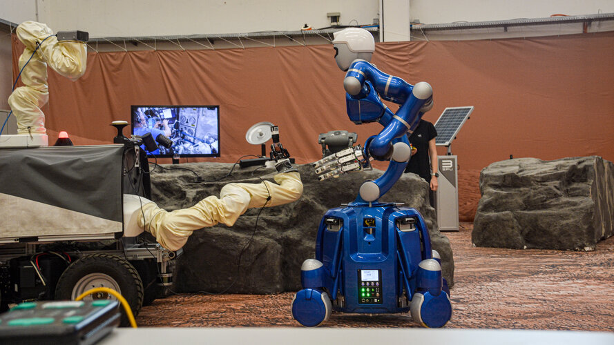 Interact rover handing sample canister to Rollin' Justin