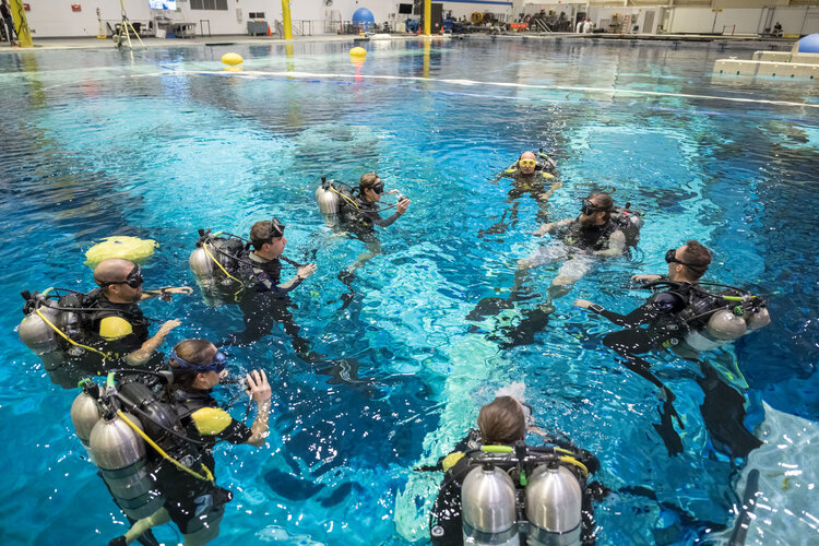 Astronaut candidates taking a plunge in NASA's Neutral Buoyancy Laboratory (NBL) for spacewalk training familiarisation.