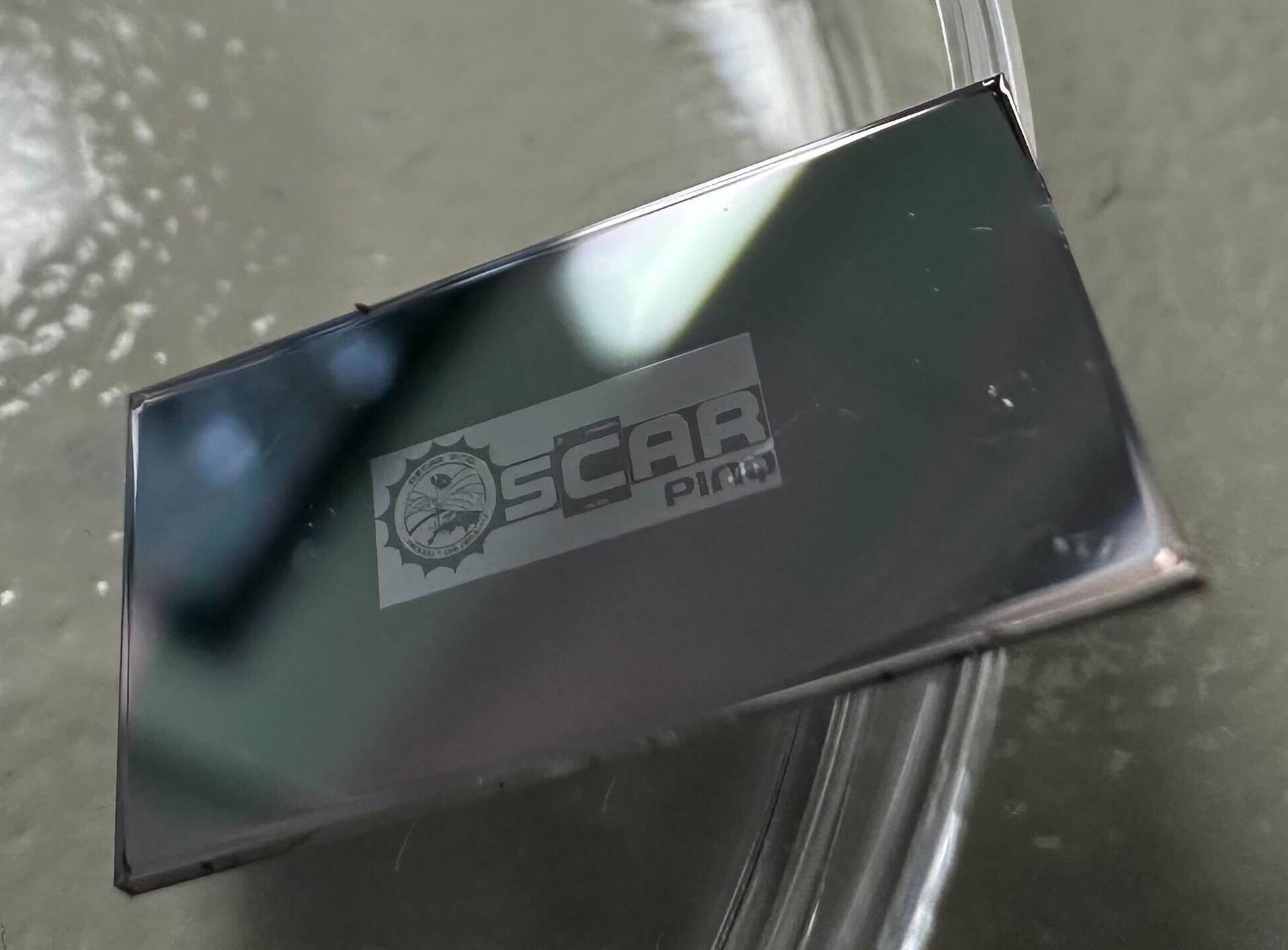 OSCAR-PINQ logo deposited on a tiny piece of silicon wafer to demonstrate the lithography capabilities.