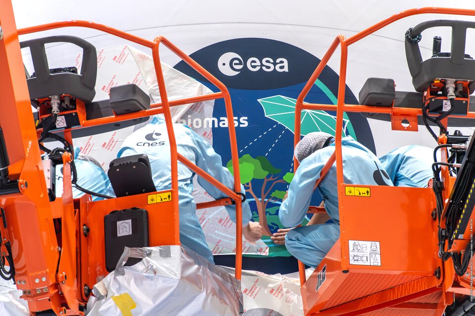 Applying the Biomass mission sticker to the rocket fairing